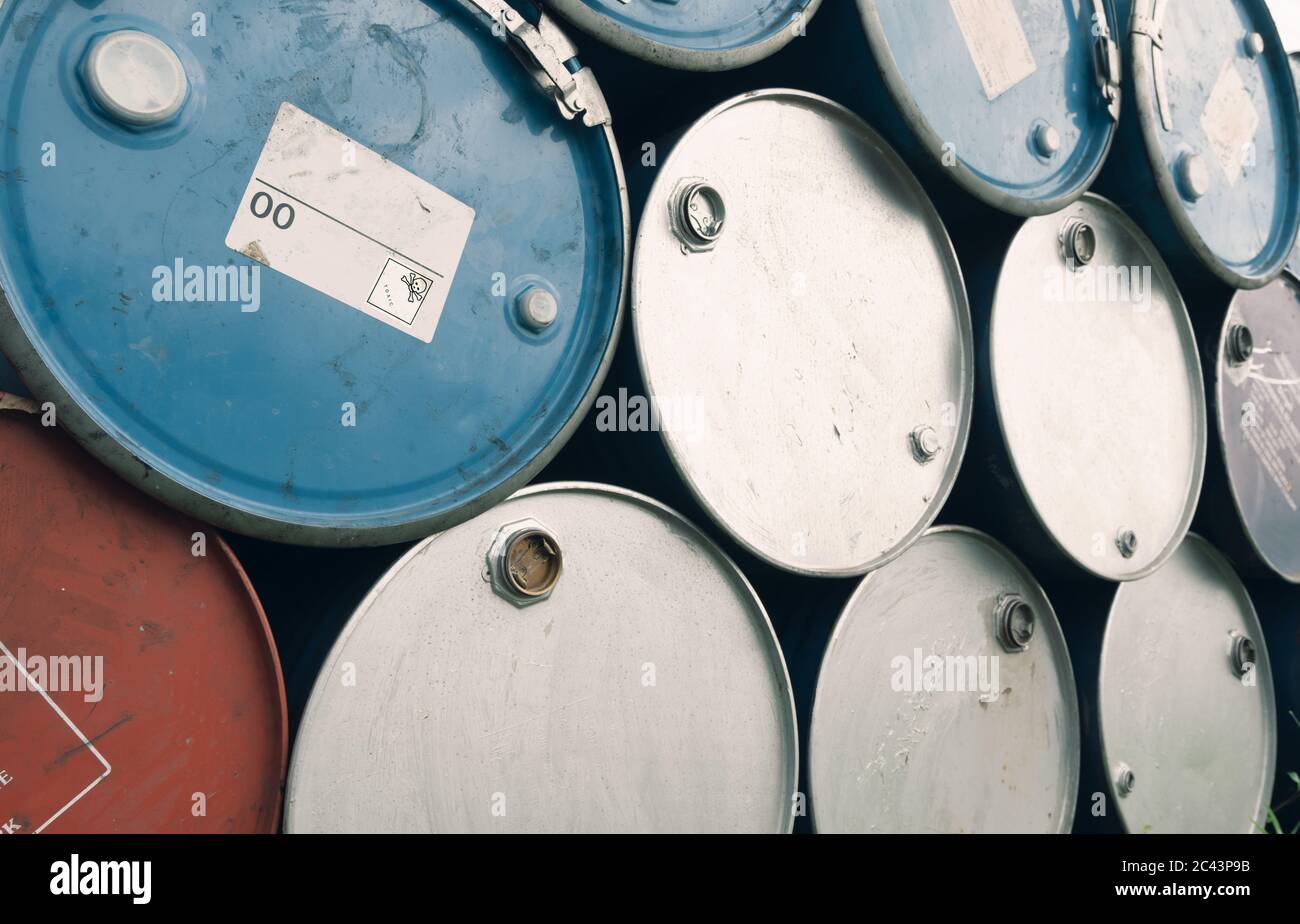 Old chemical barrels. Blue and purple oil drum. Steel oil tank. Toxic