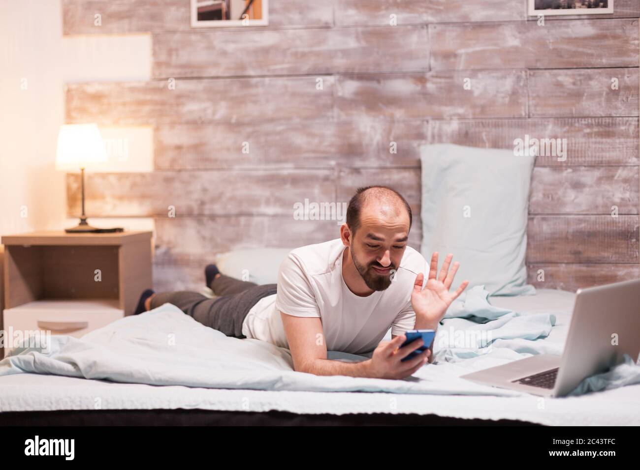 Man receiving a video call late at night while relaxing in bedroom