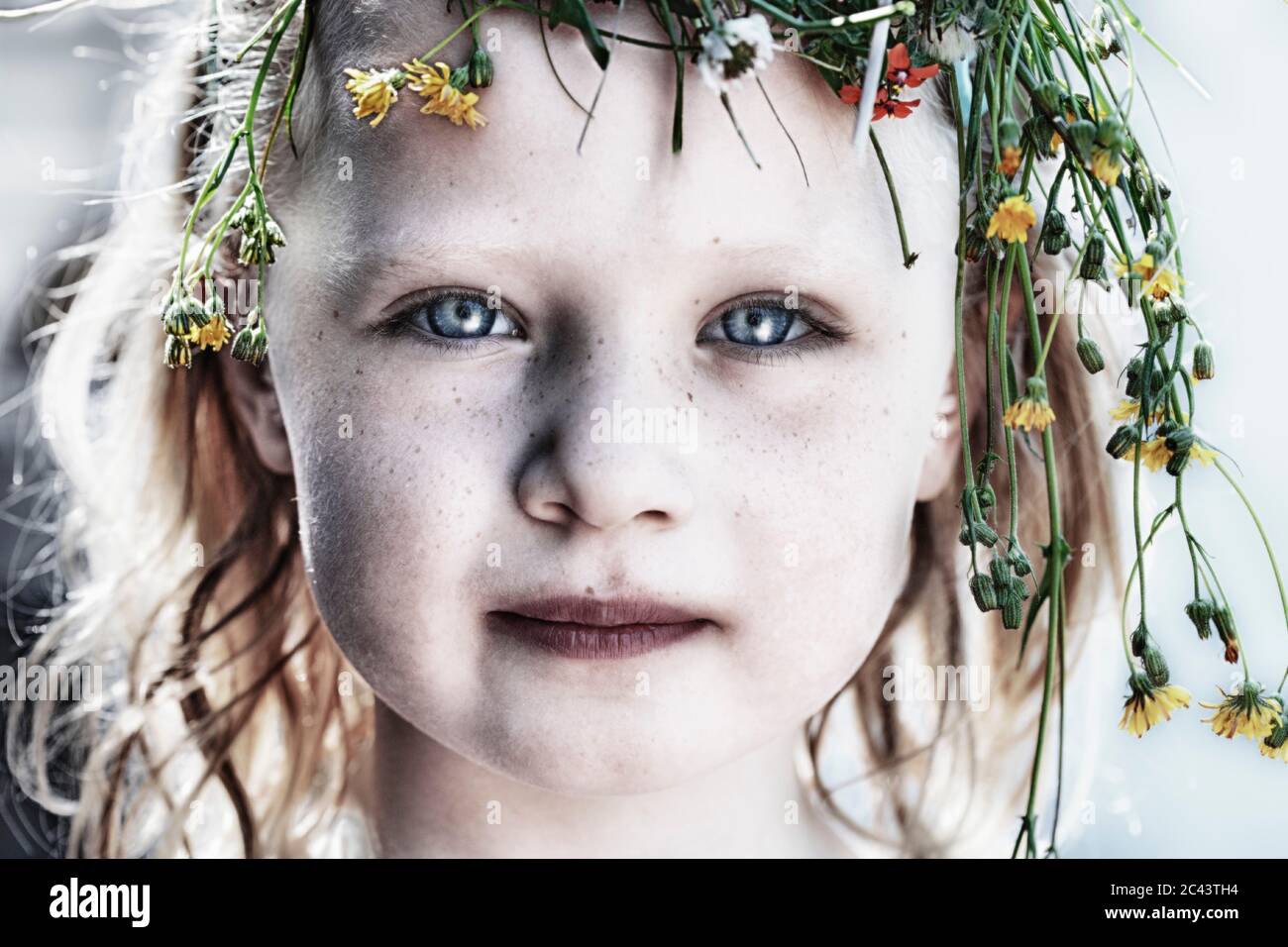 Blonde girl is wearing a wreath of flowers on her head Stock Photo - Alamy