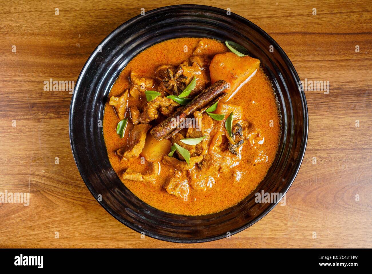 Lamb meat cooked in thick curry with potatoes and spices and garnished