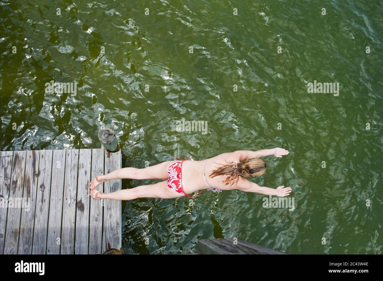 Woman jumps from a jetty into the water, Fort Walton Beach, Florida, USA Stock Photo