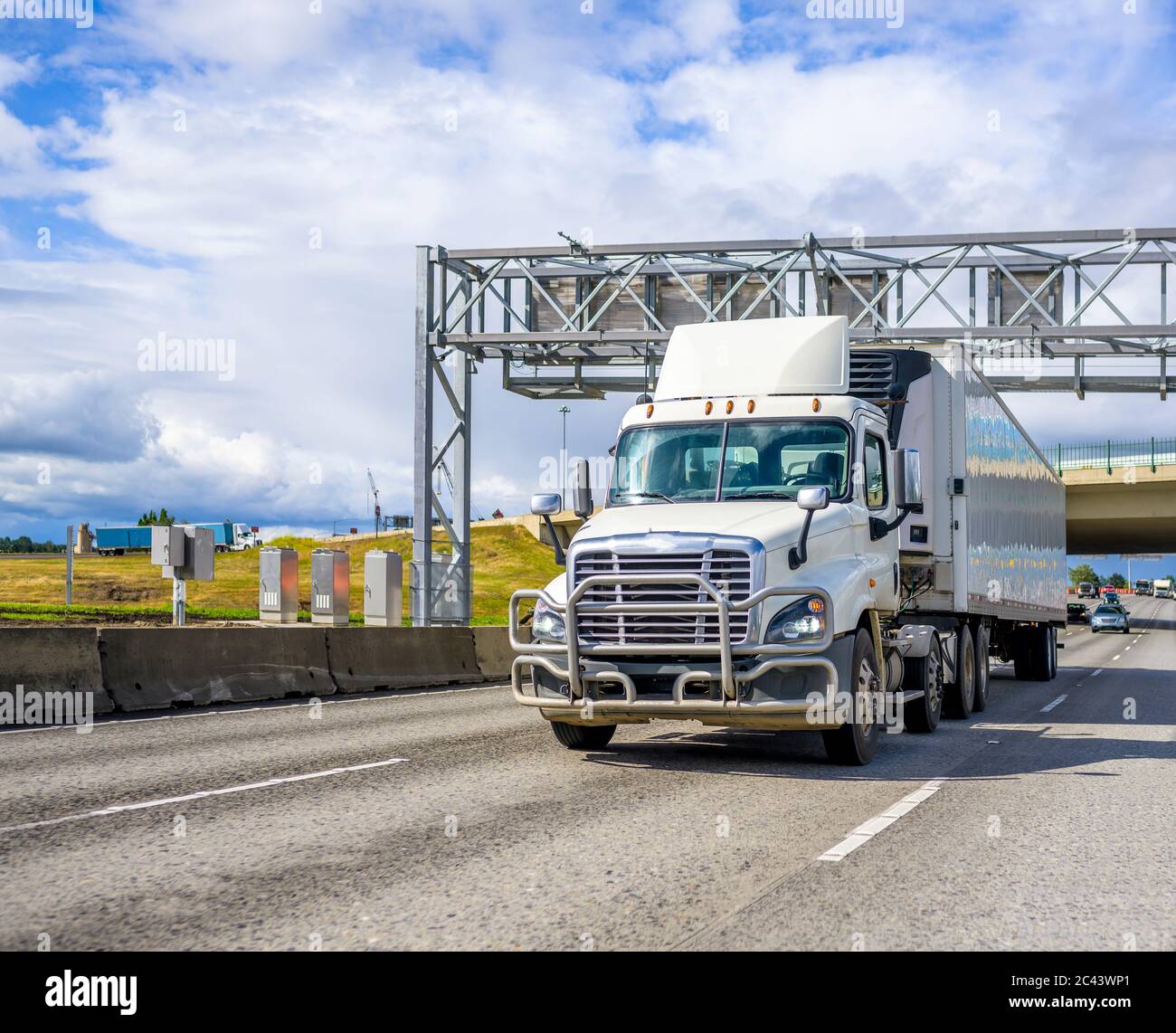 Day cab big rig semi truck with spoiler on the roof and grille guard