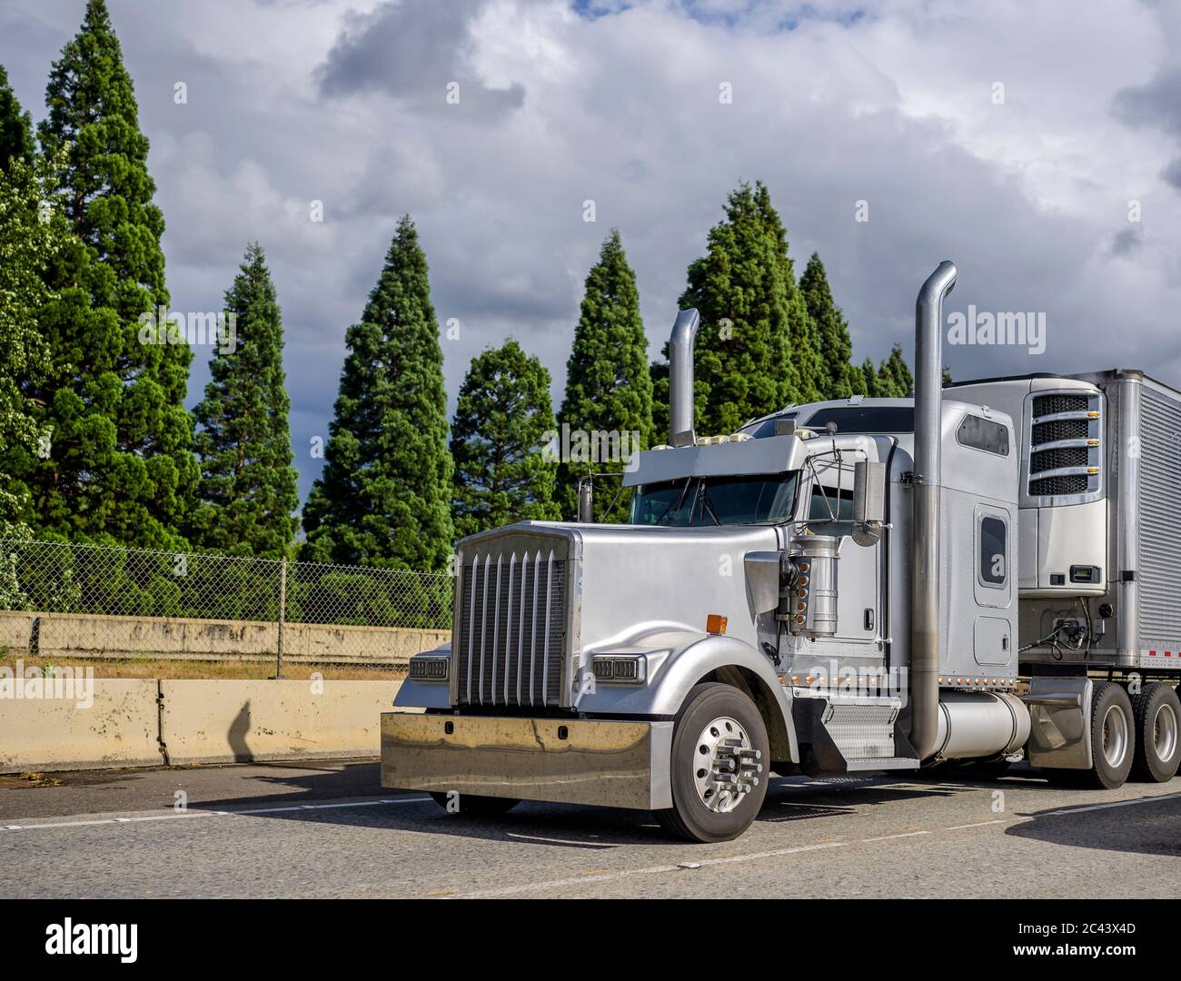 Gray classic bonnet big rig stylish semi truck with chrome accessories commercial cargo corrugated aluminum refrigerator semi trailer Stock Photo - Alamy