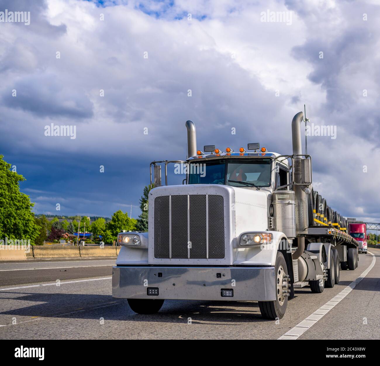 Powerful loaded classic big rig white day cab semi truck with vertical ...