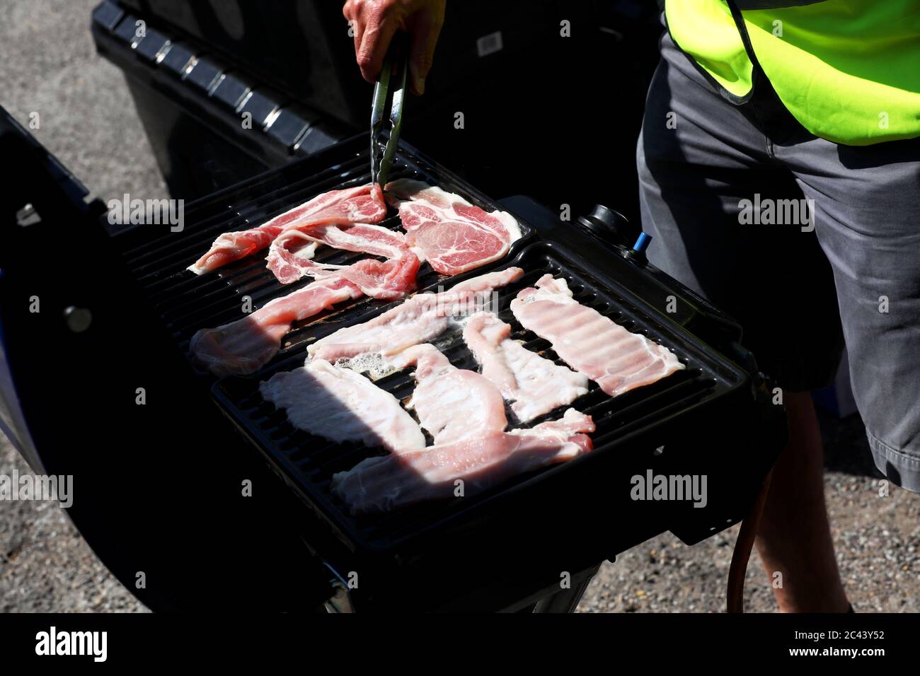 Bacon being cooked on a portable stove in Brighton, East Sussex, UK. Stock Photo