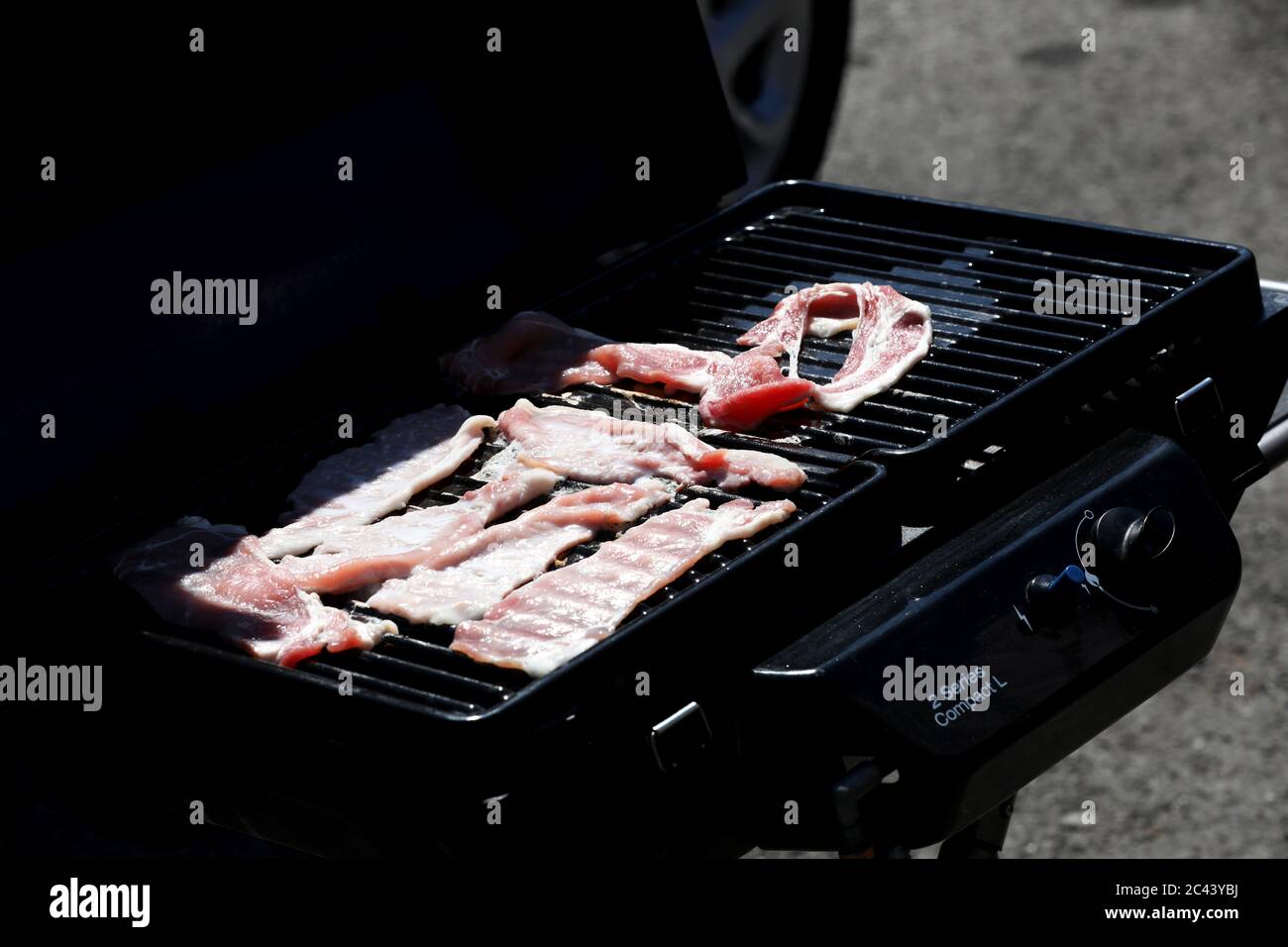 Bacon being cooked on a portable stove in Brighton, East Sussex, UK. Stock Photo
