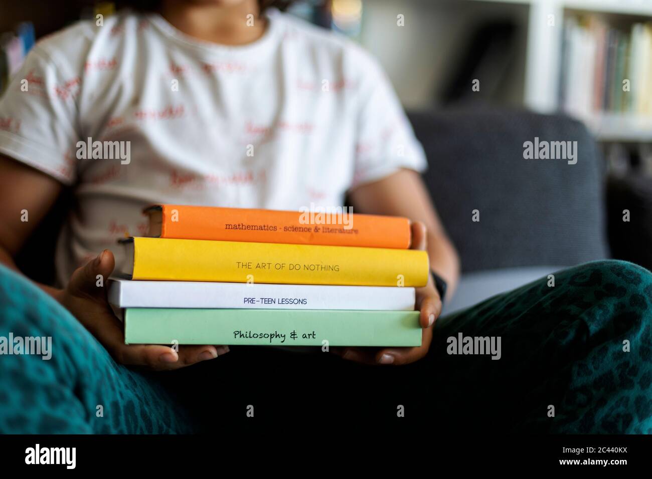 Crop view of boy holding stack of four books Stock Photo