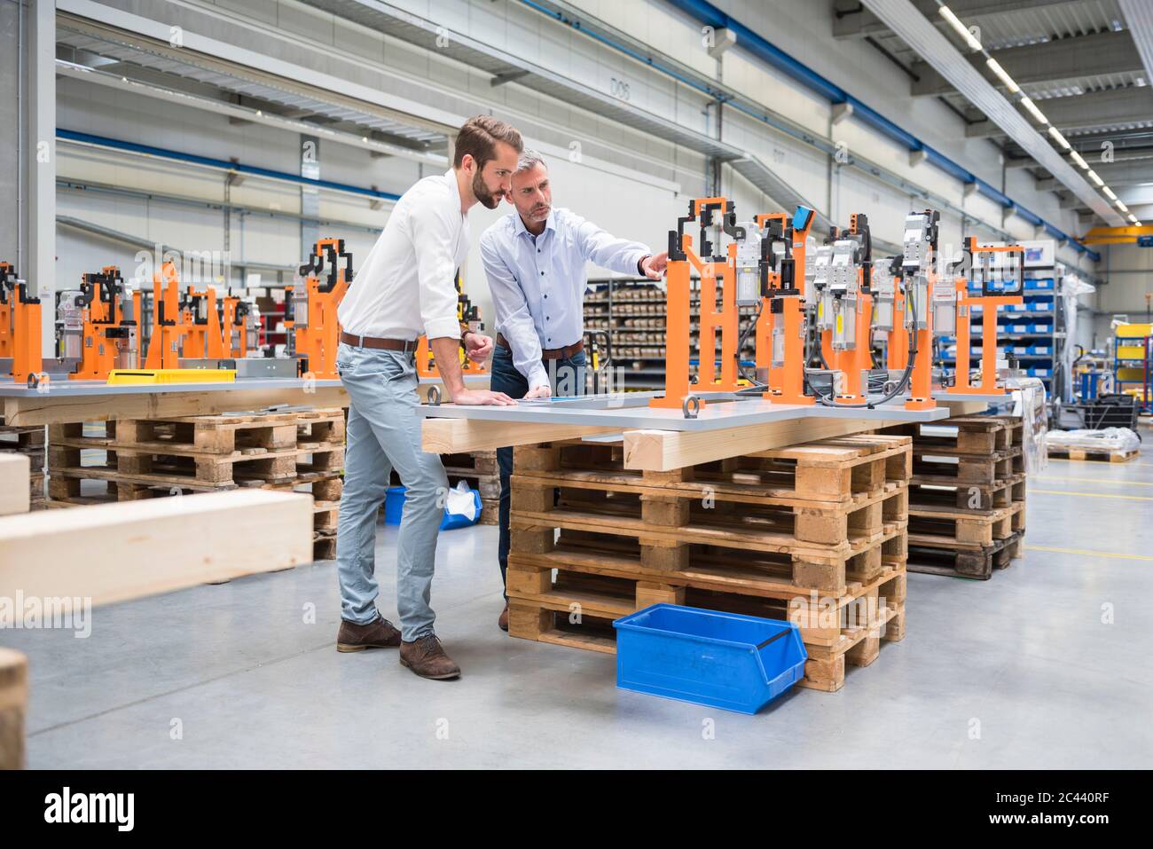 Two men talking on factory shop floor Stock Photo - Alamy