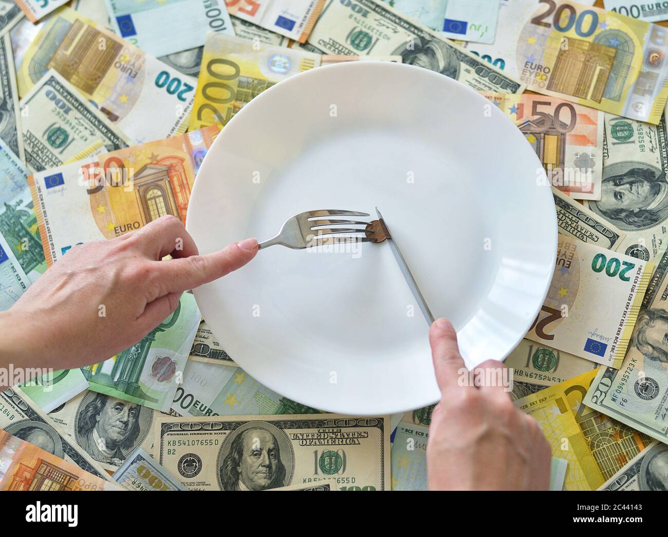 Euro cent coin on a white plate with fork and knife Stock Photo