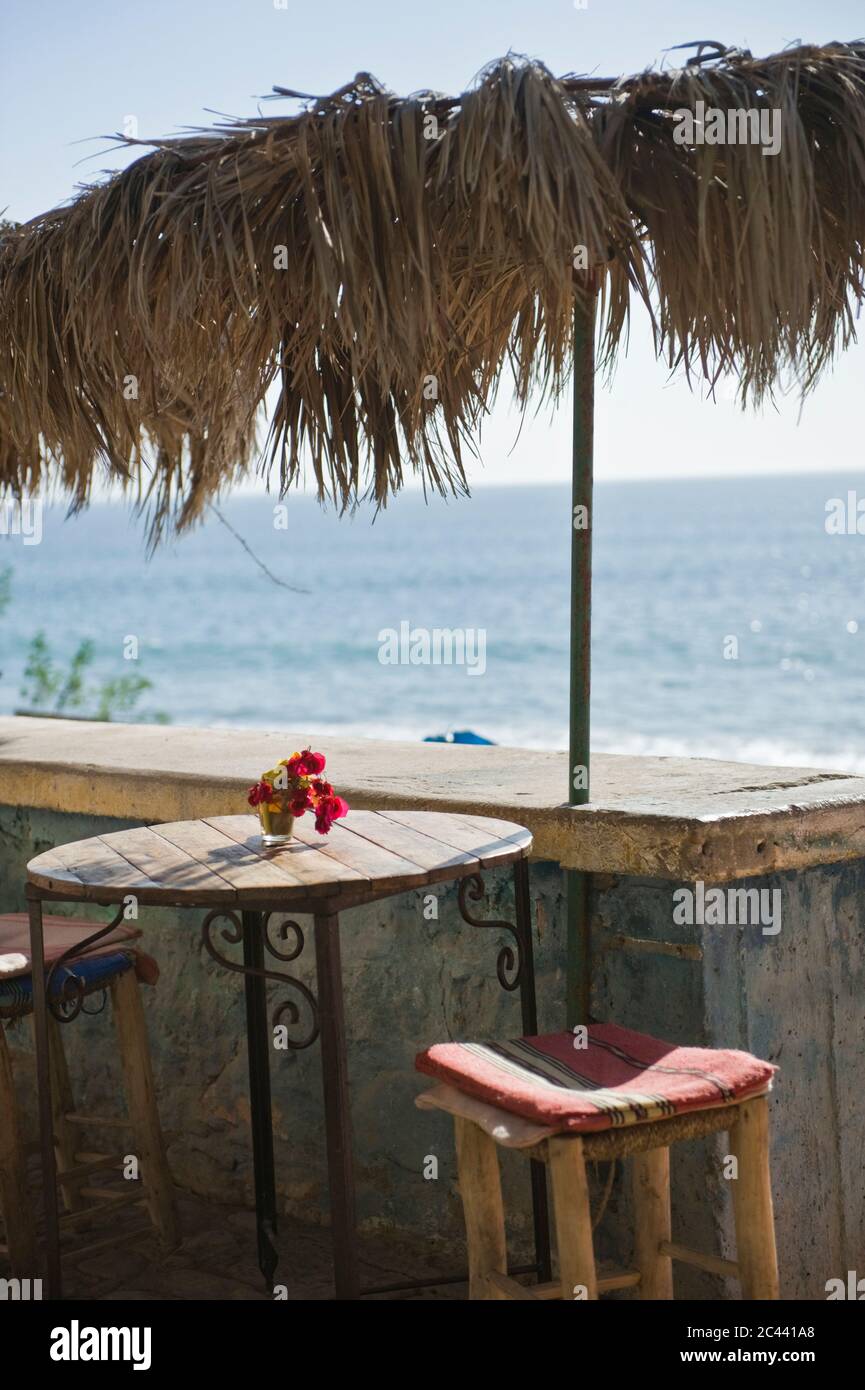 Stool and table by the sea, Tamraght, Morocco Stock Photo