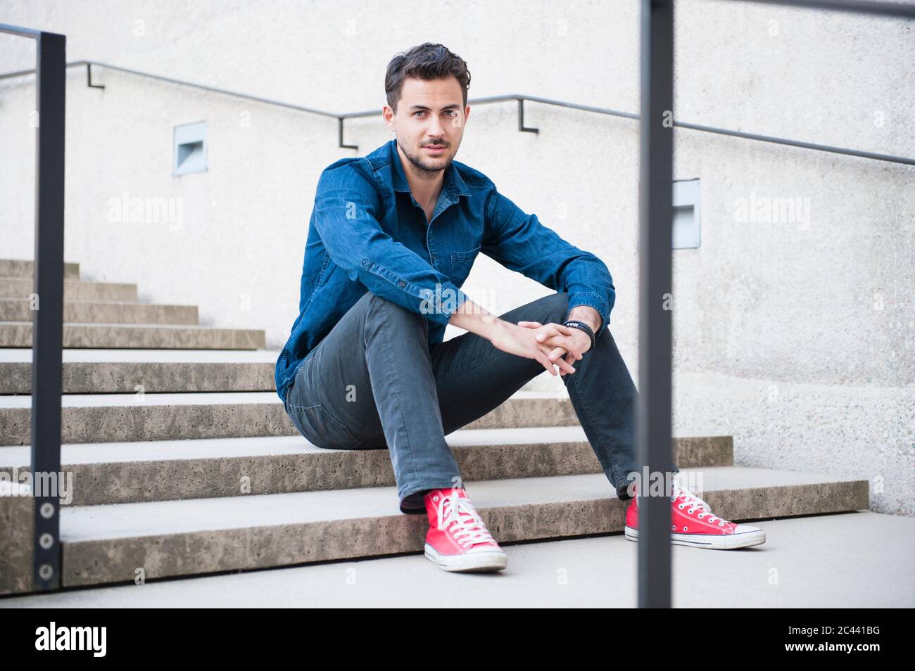 Young man sitting on stairs hi-res stock photography and images - Alamy