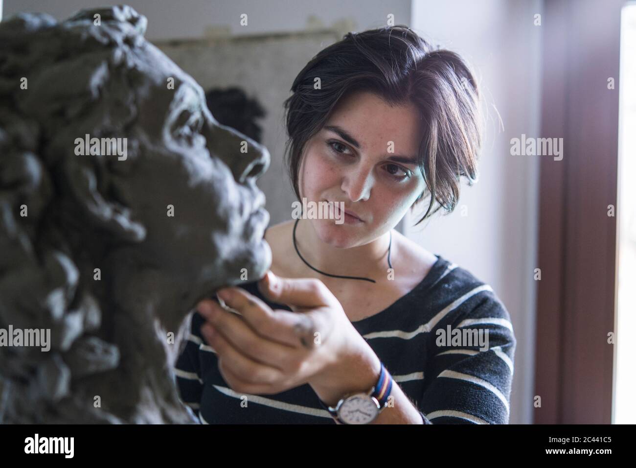 Female student looking at bust of woman Stock Photo