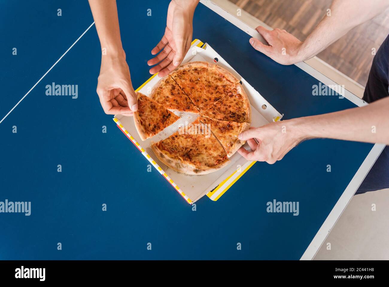 Colleagues sharing a pizza for lunch, elevated view Stock Photo