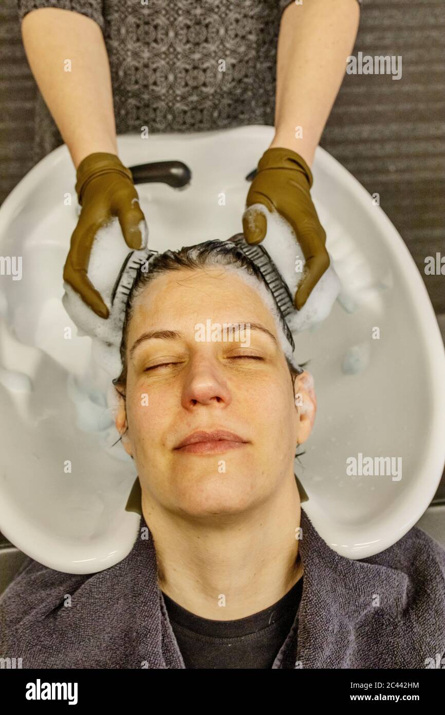 Woman in hair salon getting hair washed with brushes Stock Photo Alamy