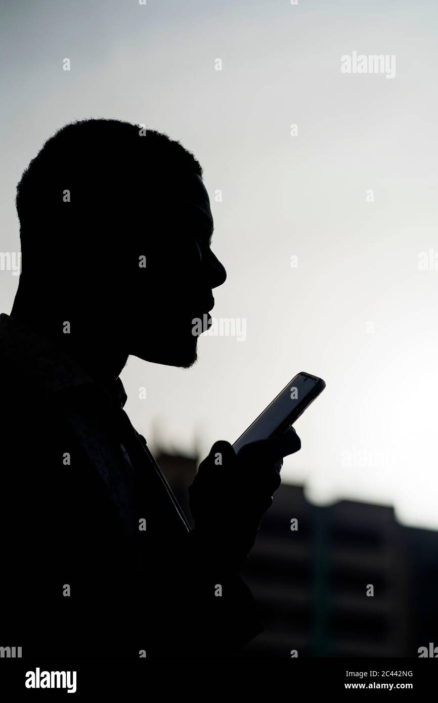 Silhouette of businessman with mobile phone Stock Photo