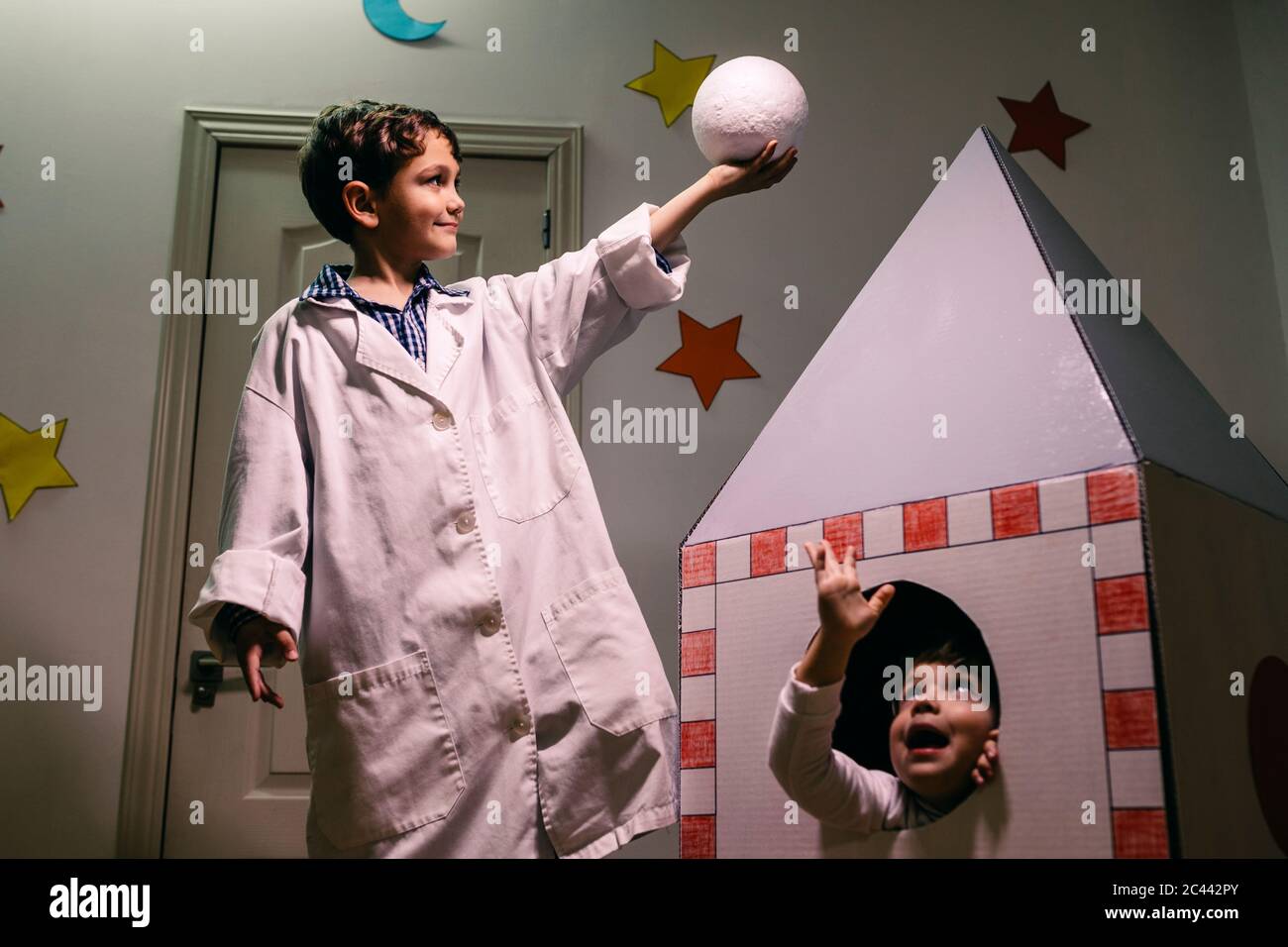 Siblings playing astronaut and researcher at home Stock Photo