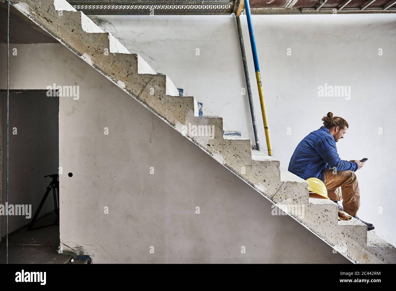 Construction worker using smartphone at construction site Stock Photo