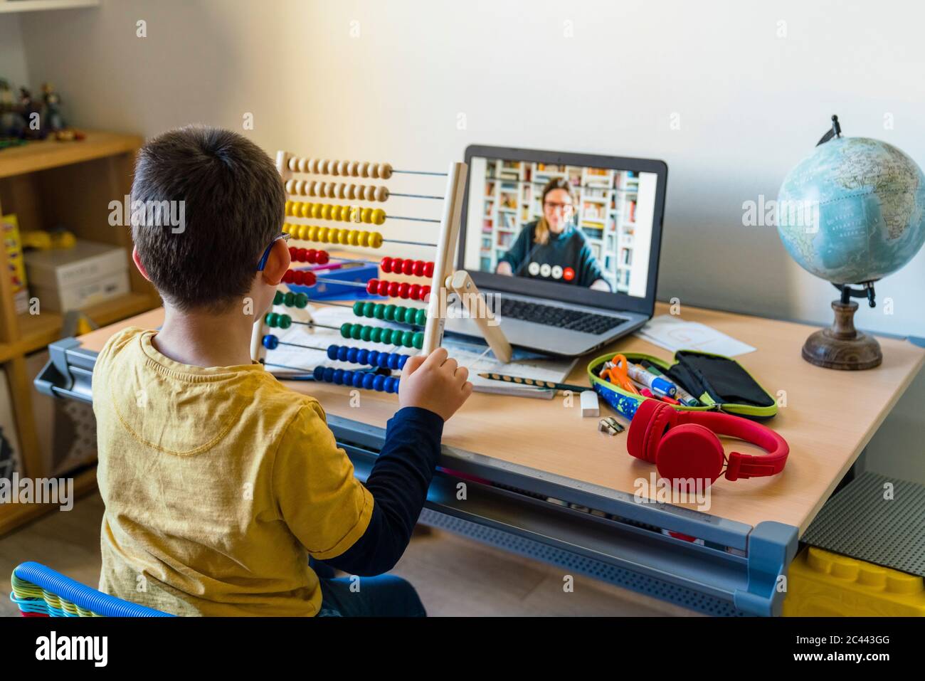 Boy using abacus with teacher on video call during homeschooling Stock Photo