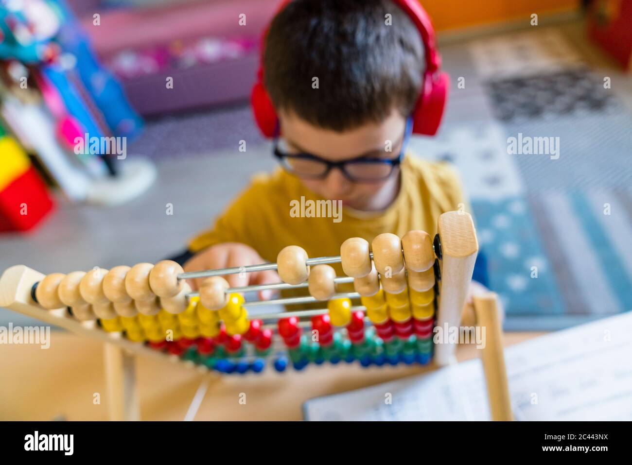 Boy calculating with abacus while sitting at home Stock Photo
