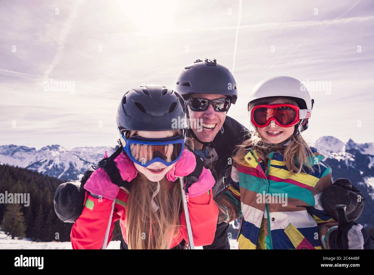 Happy father embracing daughters while enjoying ski holiday at Spitzingsee, Bavaria, Germany Stock Photo