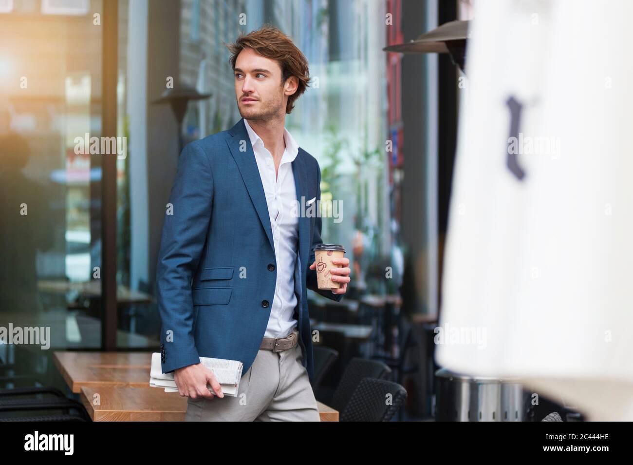 Portrait of young businessman with newspaper and coffee to go outdoors Stock Photo