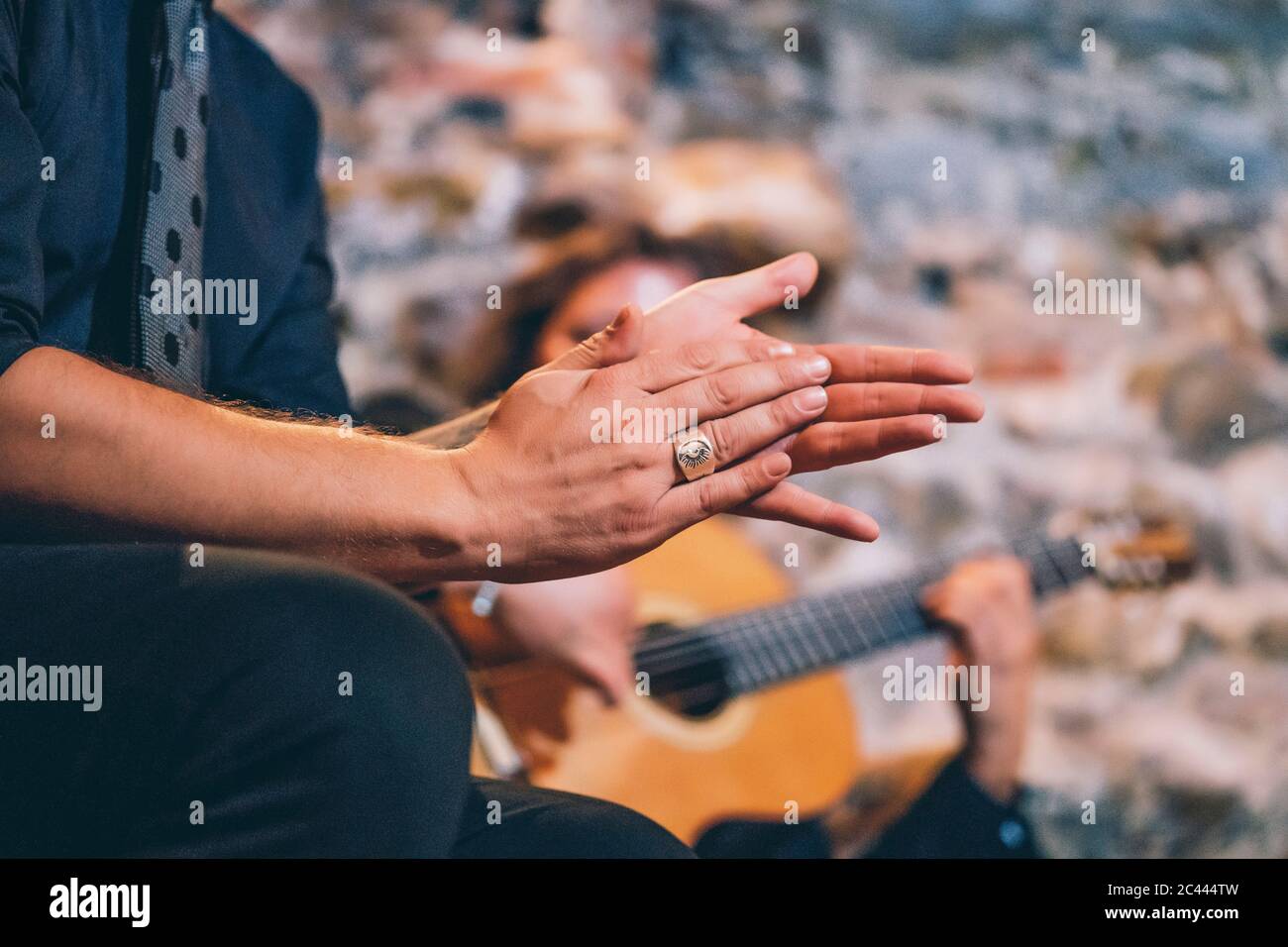 Close-up of singer clapping hands while man playing guitar in club Stock Photo