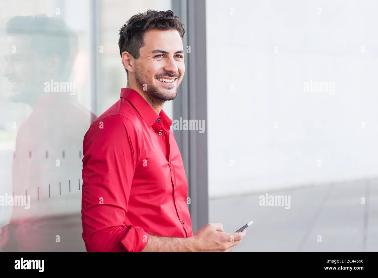 Smiling businessman using smartphone Stock Photo