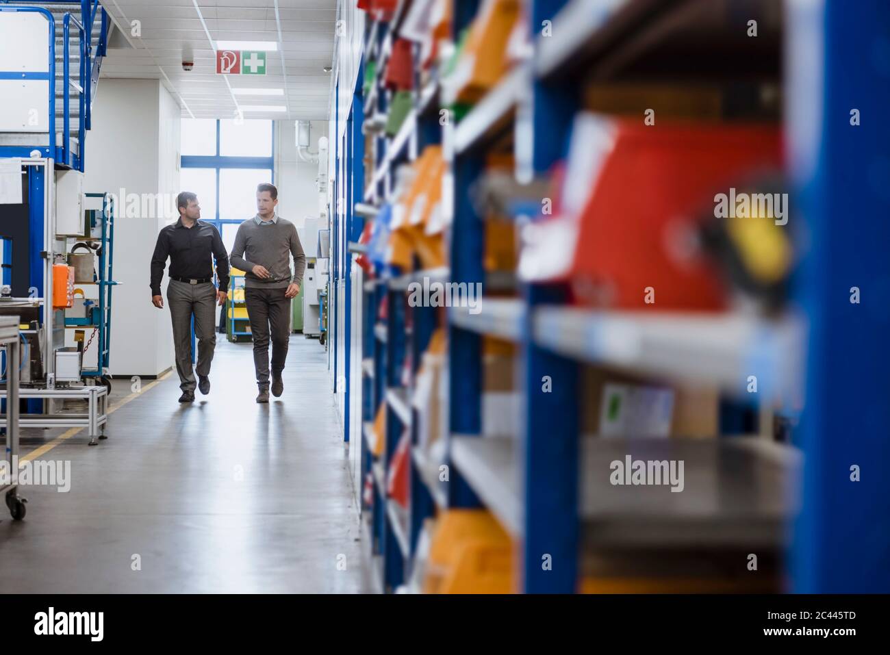 Two men walking and talking in factory Stock Photo - Alamy