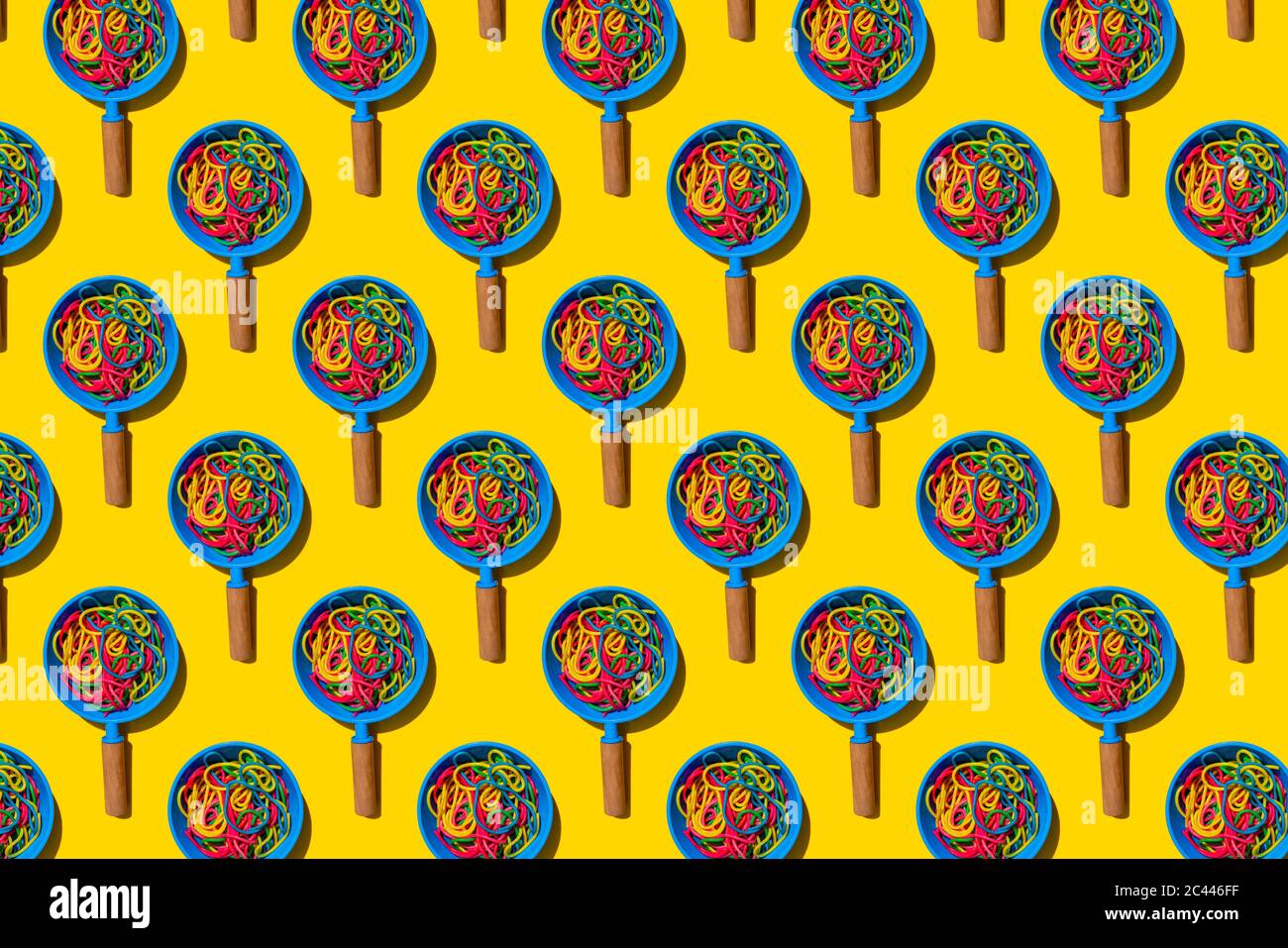Pattern of toy frying pans with colorful pasta Stock Photo