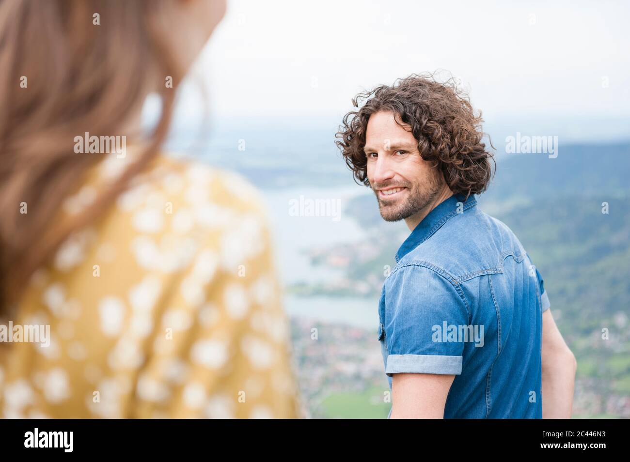 Smiling handsome man looking back at woman Stock Photo