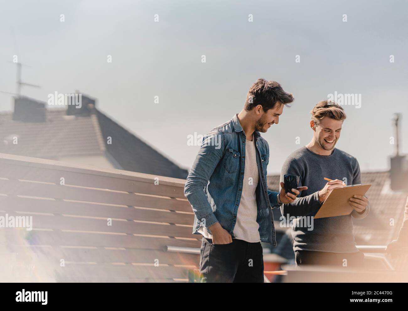 Colleagues brainstorming on balcony, writing down their ideas Stock Photo