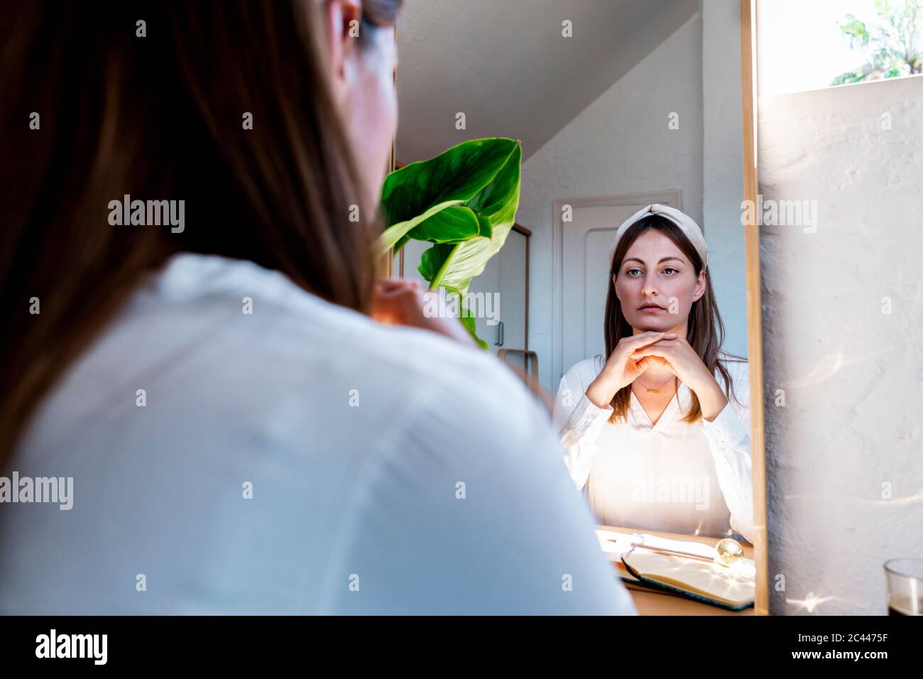 Beautiful woman looking at self in mirror reflection Stock Photo