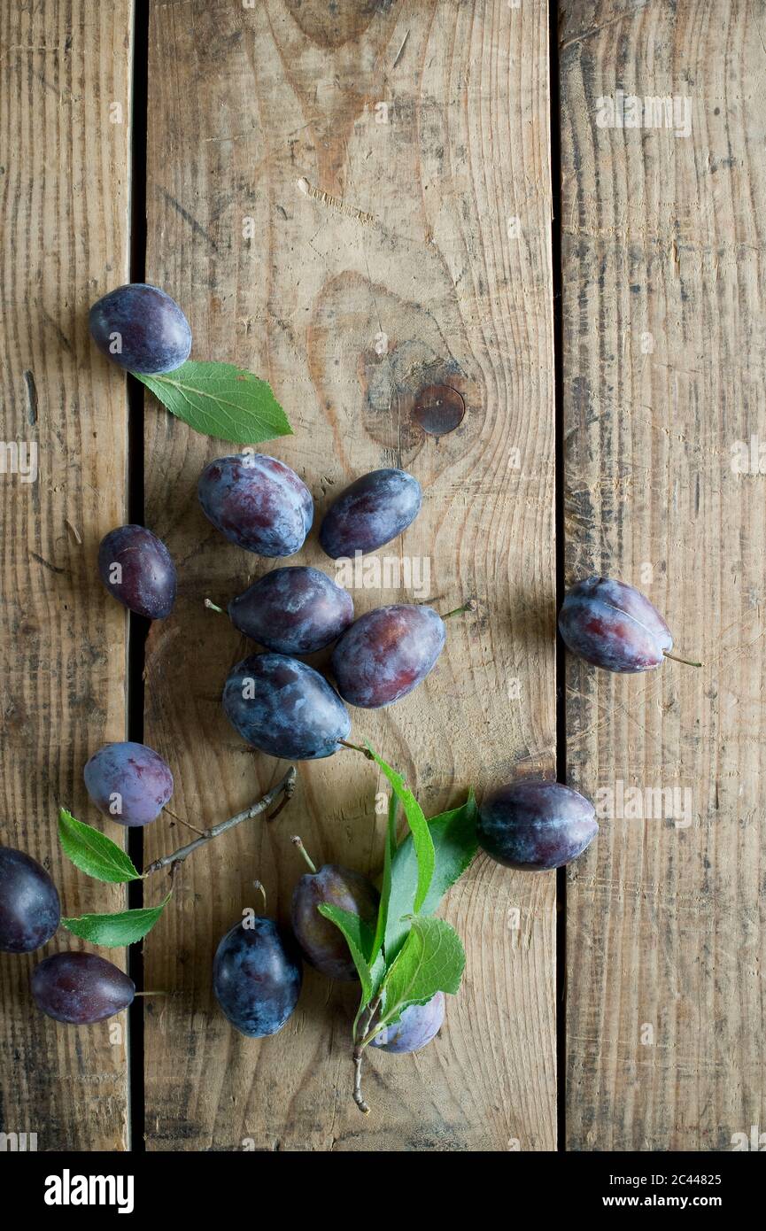 Fresh plums on wooden surface Stock Photo