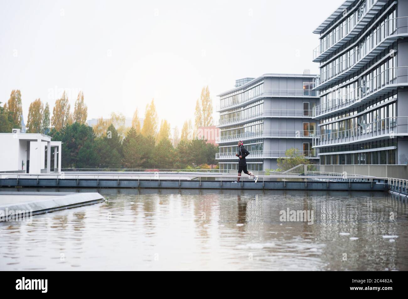 Young man with headphones jogging in the city Stock Photo