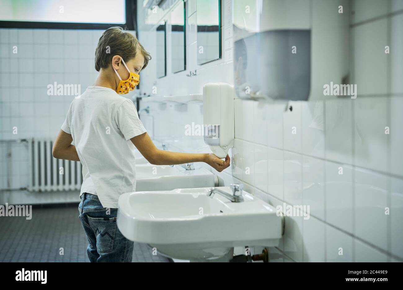 Boy wearing mask on school toilet washing his hands Stock Photo - Alamy