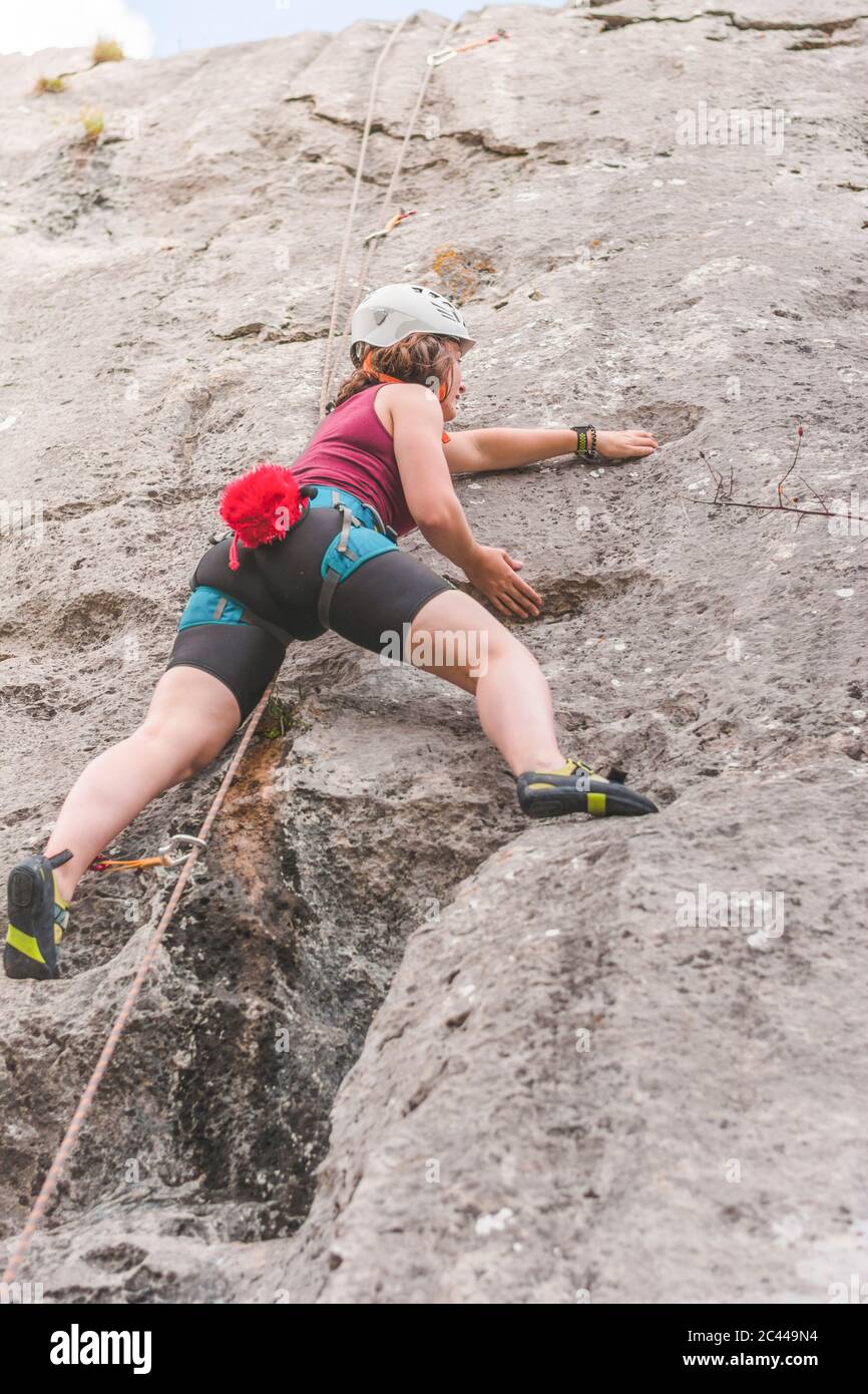 Young woman climbing rock Stock Photo