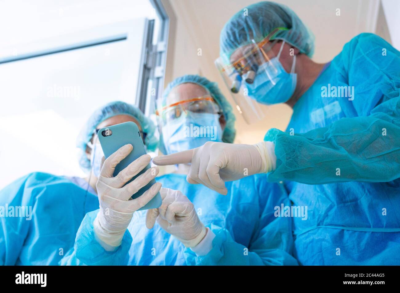 Healthcare workers discussing over mobile phone at clinic Stock Photo