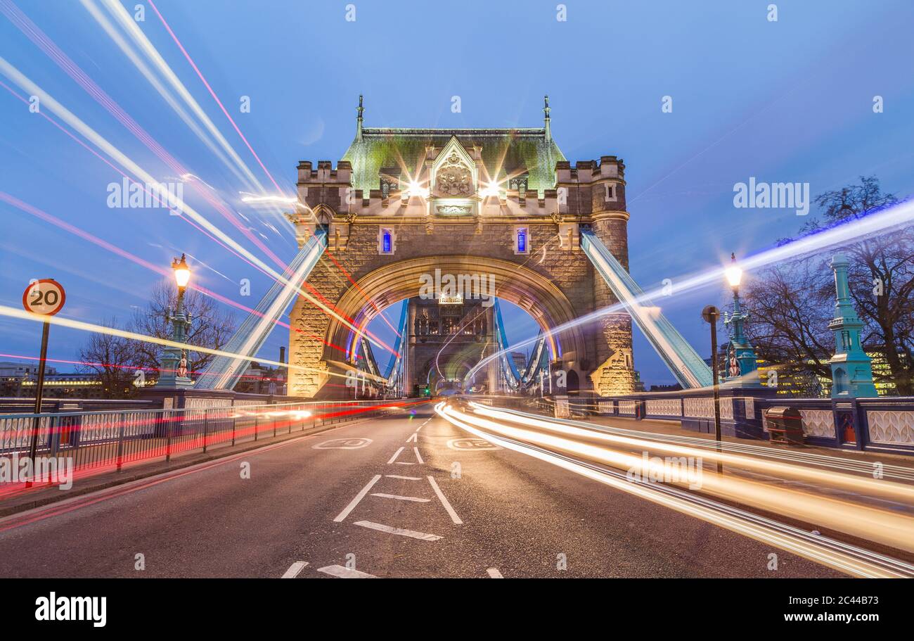 The entrance to Tower Bridge in London with the blur of traffic going past Stock Photo