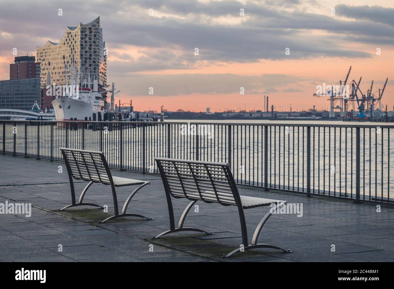 Germany, Hamburg, Empty benches of Saint Pauli Piers at dusk Stock Photo