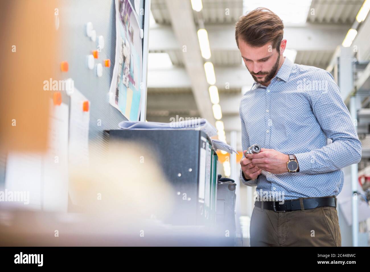 Man examining workpiece in a factory Stock Photo