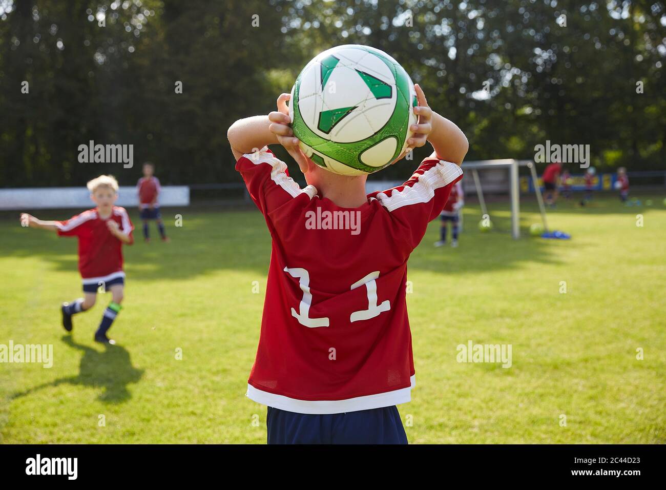 Soccer boy throwing ball on field Stock Photo Alamy