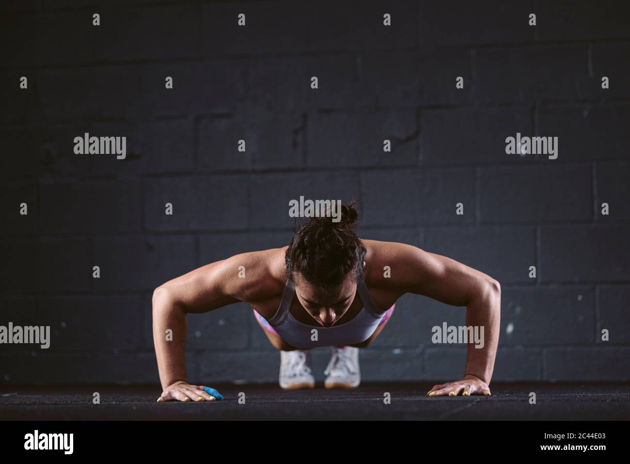 Woman practicing push-up exercise at gym Stock Photo
