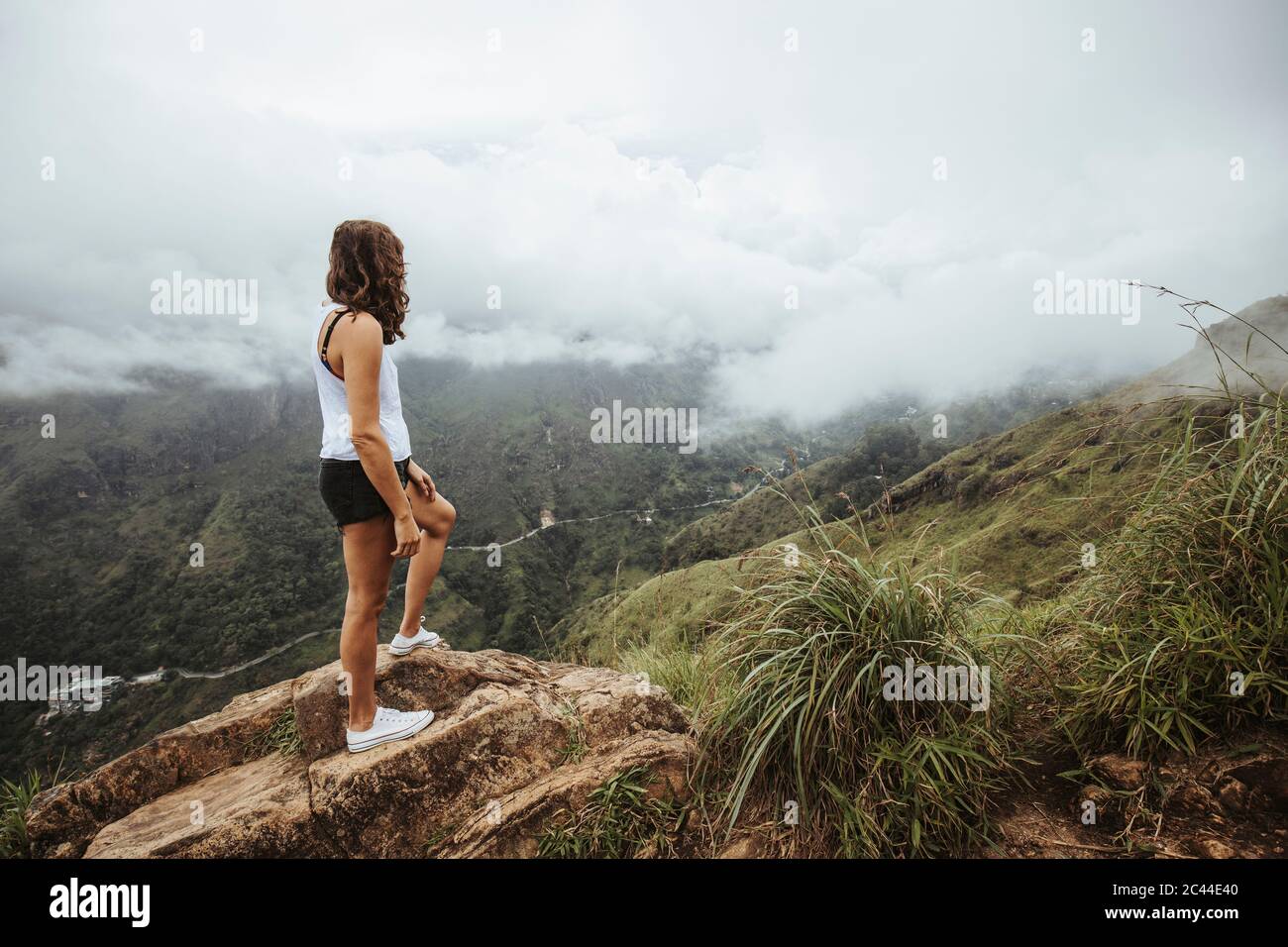 Sri Lanka, Uva Province, Ella, Female hiker standing on boulder at Little Adams Peak Stock Photo
