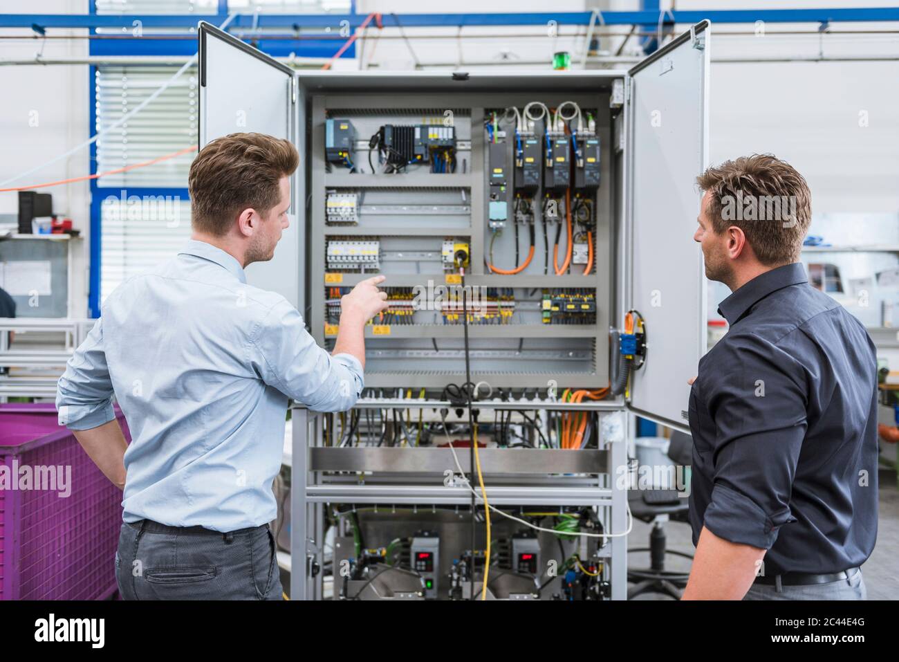 Two technicians working on circuit in factory Stock Photo