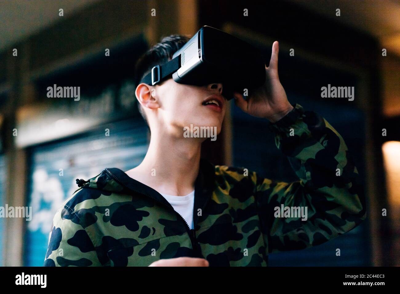 Young man looking through virtual reality simulator outdoors Stock Photo