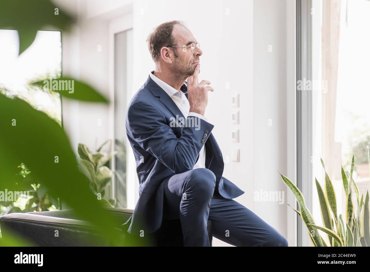 Pensive businessman looking out of window Stock Photo