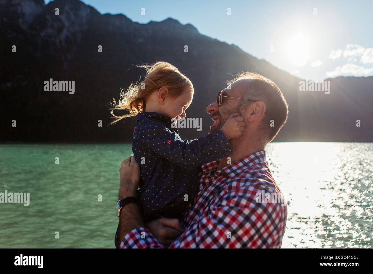 Father carrying daughter against mountain and lake at Achensee, Tyrol State, Austria Stock Photo