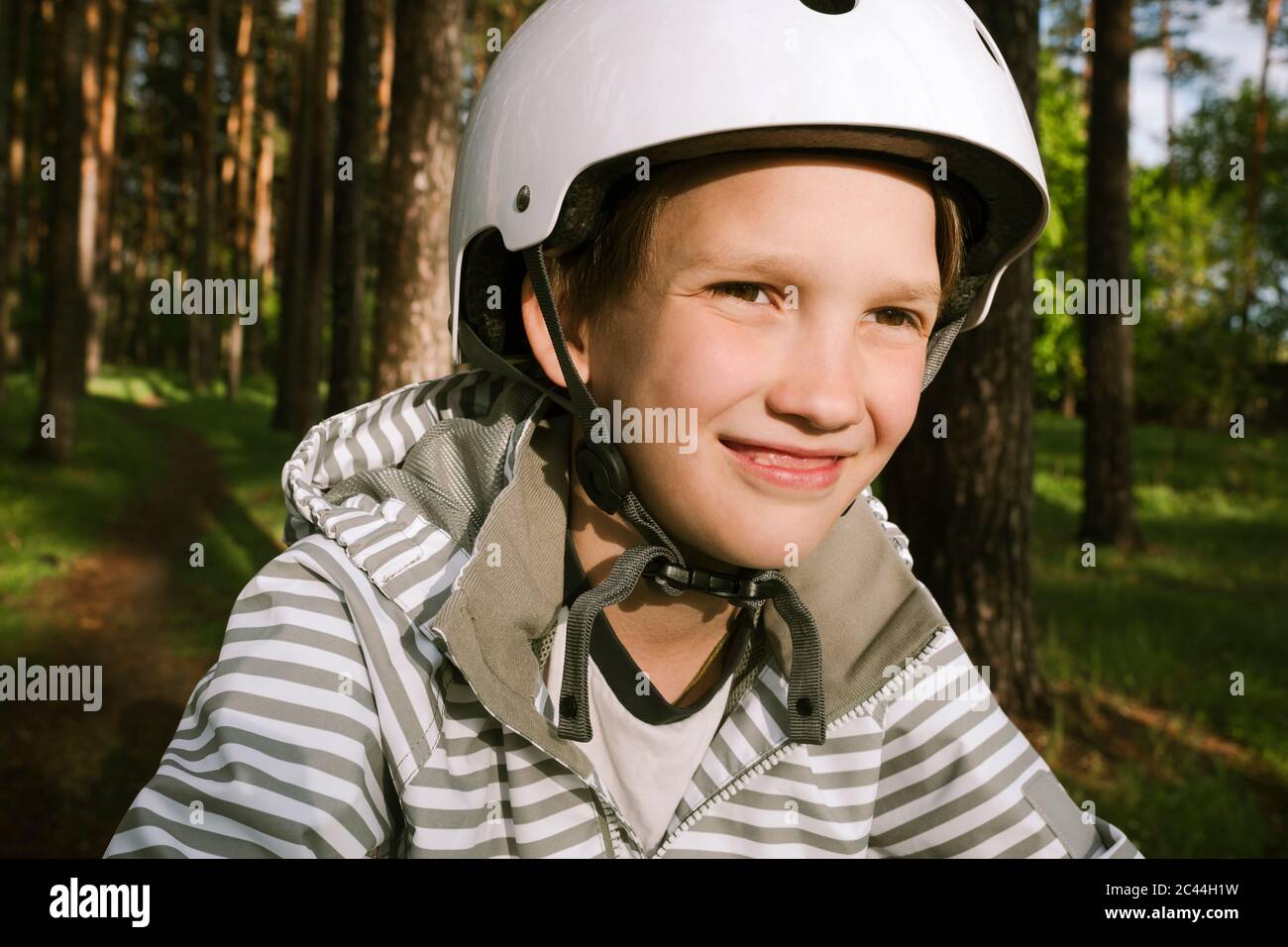 Happy boy wearing cycling helmet in forest Stock Photo