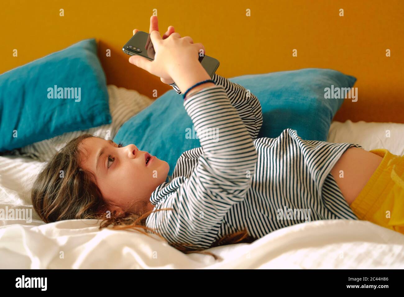 Girl lying bed mobile hi-res stock photography and images - Alamy