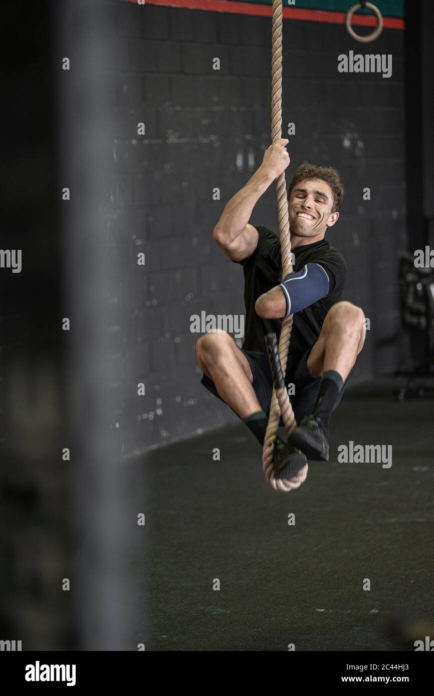 Athlete with an amputated arm climbing rope Stock Photo